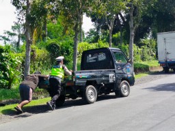 Sigap, Bripka Ngurah Nopi Bantu Pengendara Dorong Mobil Mogok