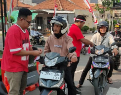 Semarak HUT RI ke-81, Satpas Colombo Surabaya Kenakan Seragam Merah Putih dan Bagikan Bendera kepada Pemohon
