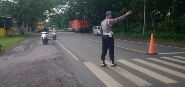 Polsek Saradan Telah Melaksanakan Giat Pengaturan Lalu Lintas di Pagi Hari di Depan SMA Negri 1 Saradan
