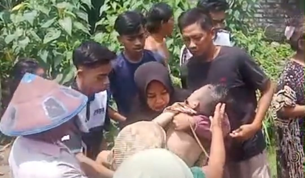 Warga mengangkat jasad balita yang ditemukan meninggal dunia setelah tenggelam di aliran Sungai Kamoning, Sampang