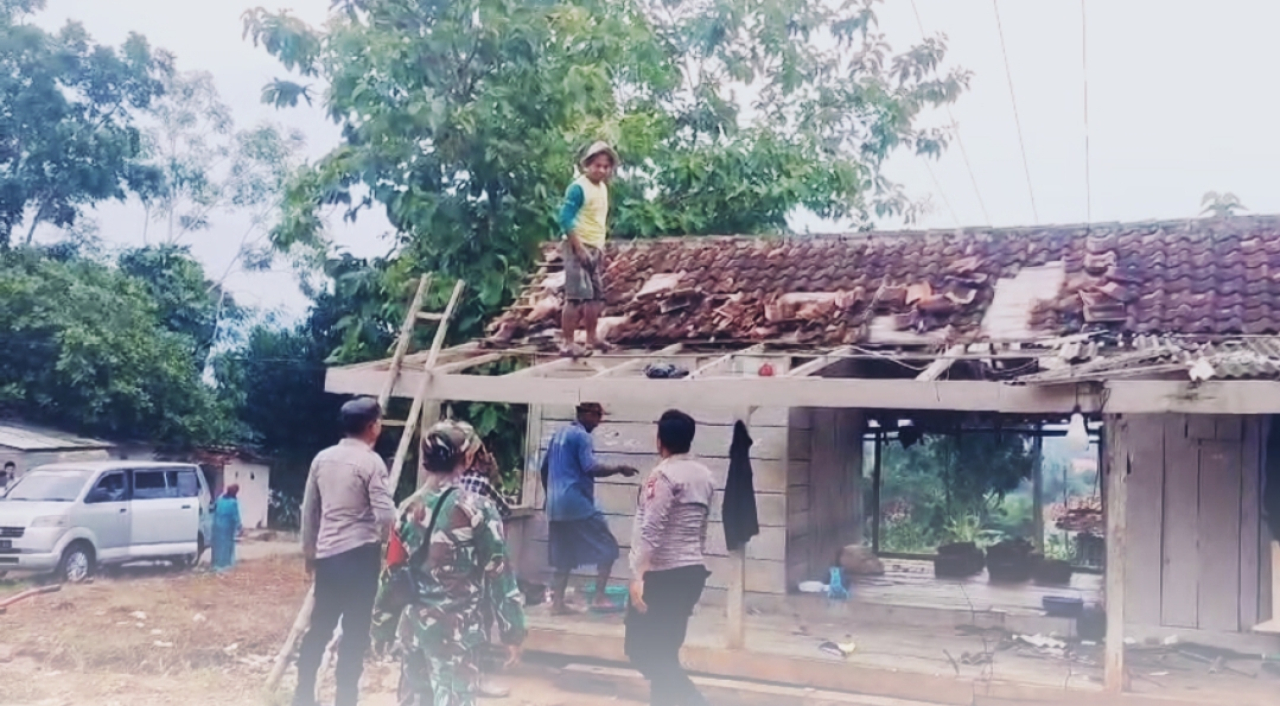Moment anggota polsek dan anggota Dan ramil Guluk-Guluk bersama warga bersihkan puing-puing akibat angin putting beliung .