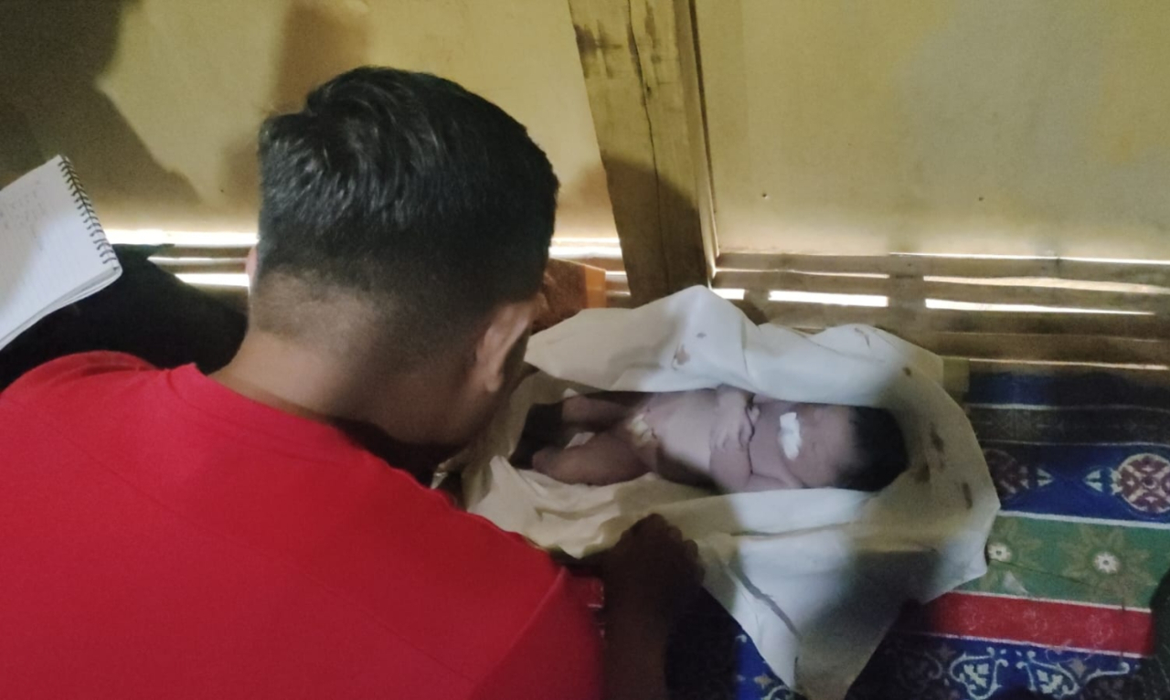 Warga memeriksa kondisi bayi perempuan yang ditemukan meninggal dunia setelah ditemukan di dalam kardus di pinggir jalan Dusun Nagasari Timur, Desa Tlambah, Kecamatan Karang Penang, Sampang/Bn.