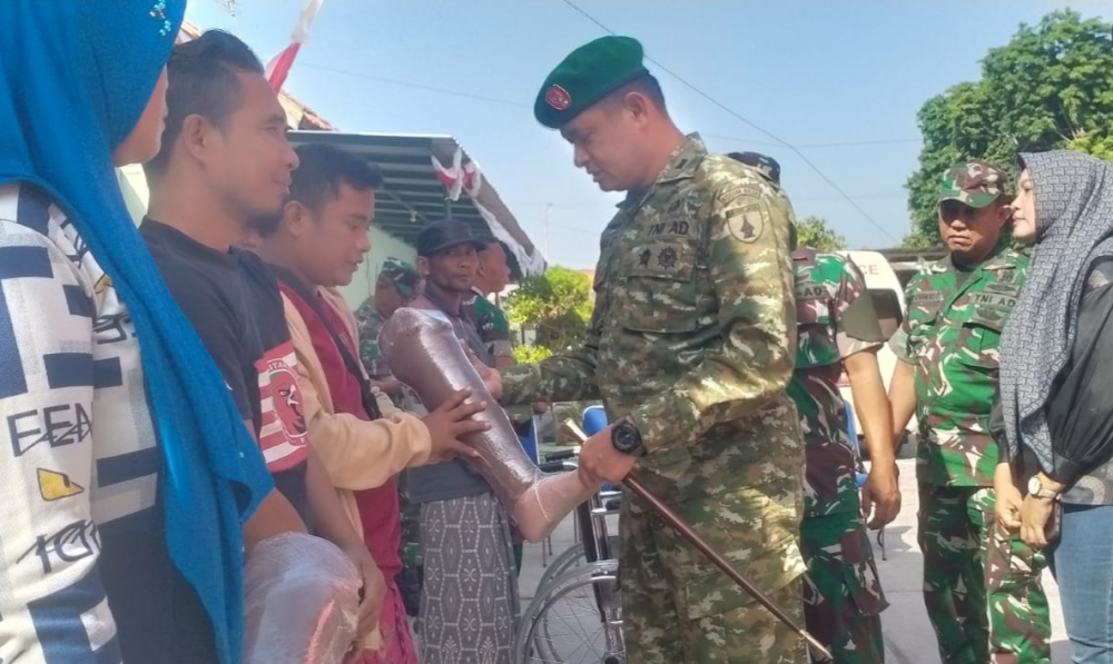 Dandim 0828/Sampang menyerahkan bantuan kaki palsu kepada penyandang disabilitas dalam kegiatan bakti sosial di Poskes Dim 0828/Sampang/istimewa/Bn.